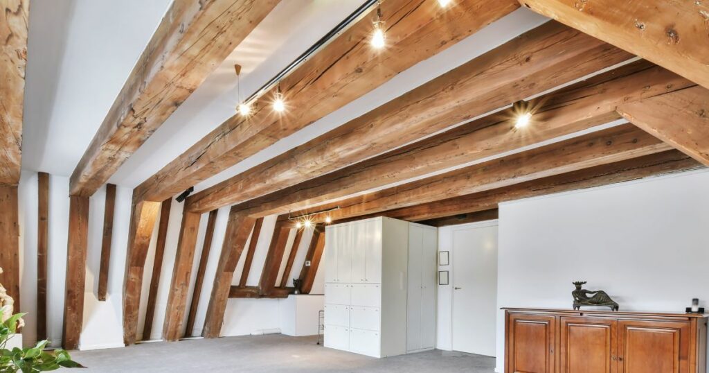 clean light fixtures in attic - furniture in guest room - wooden beams - attic floor
